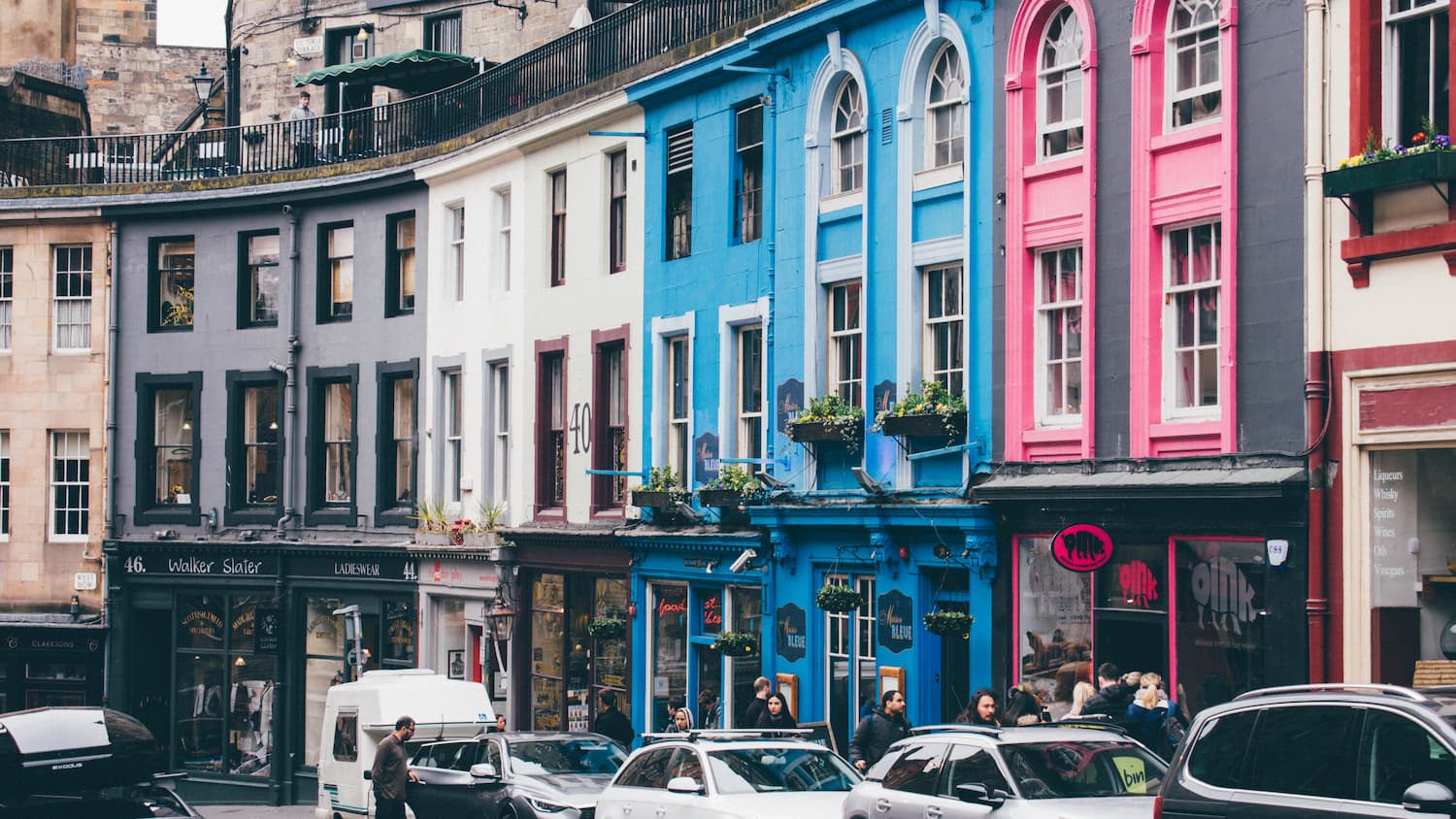 A row of coloured buildings, on a curved stret.